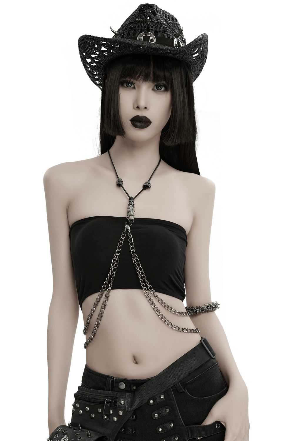 Chic model wearing an elegant multi-chain body harness layered over a black strapless top with a stylish cowboy hat.