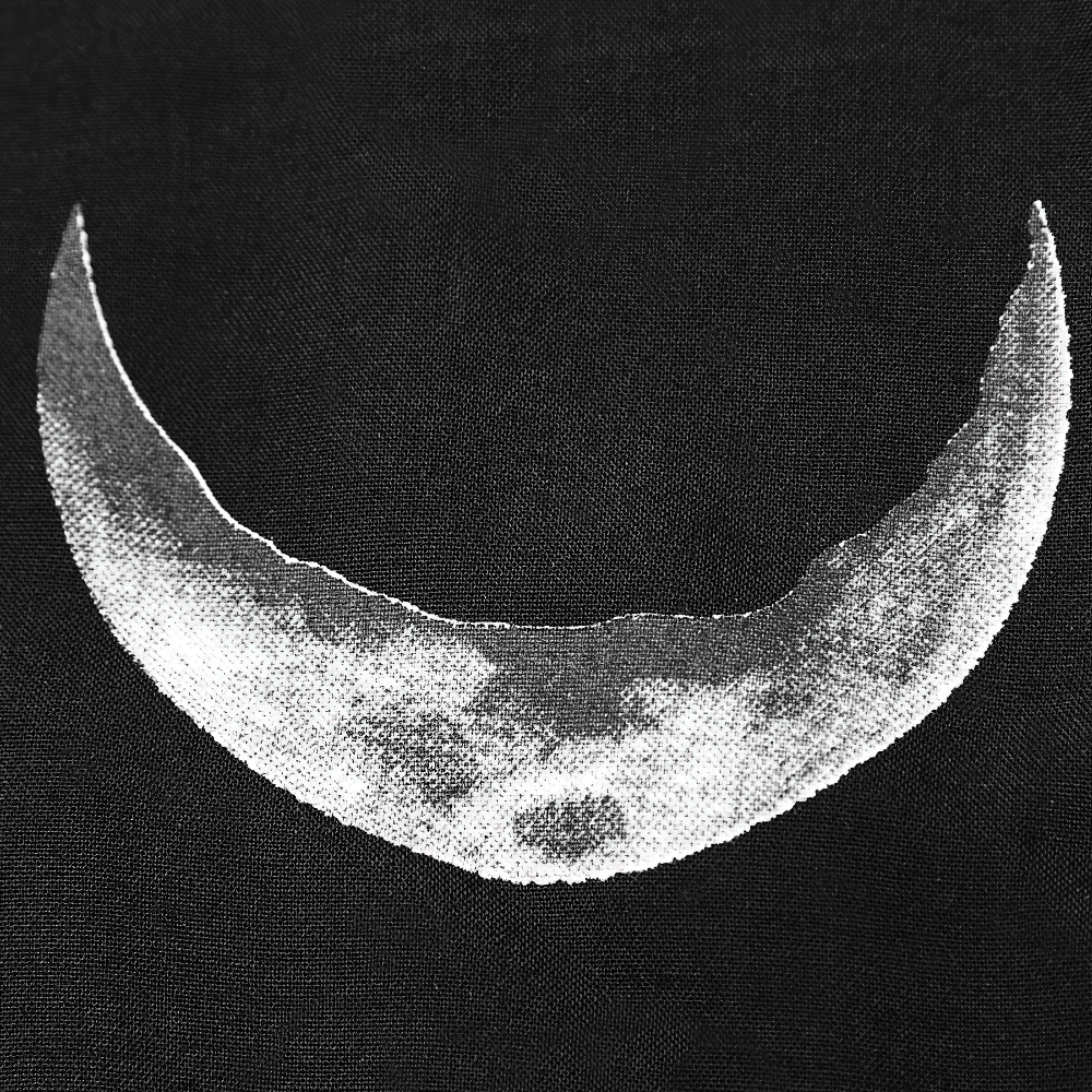 Celestial design of moon phase on black fabric, capturing elegance and mystery in stylish shawl.