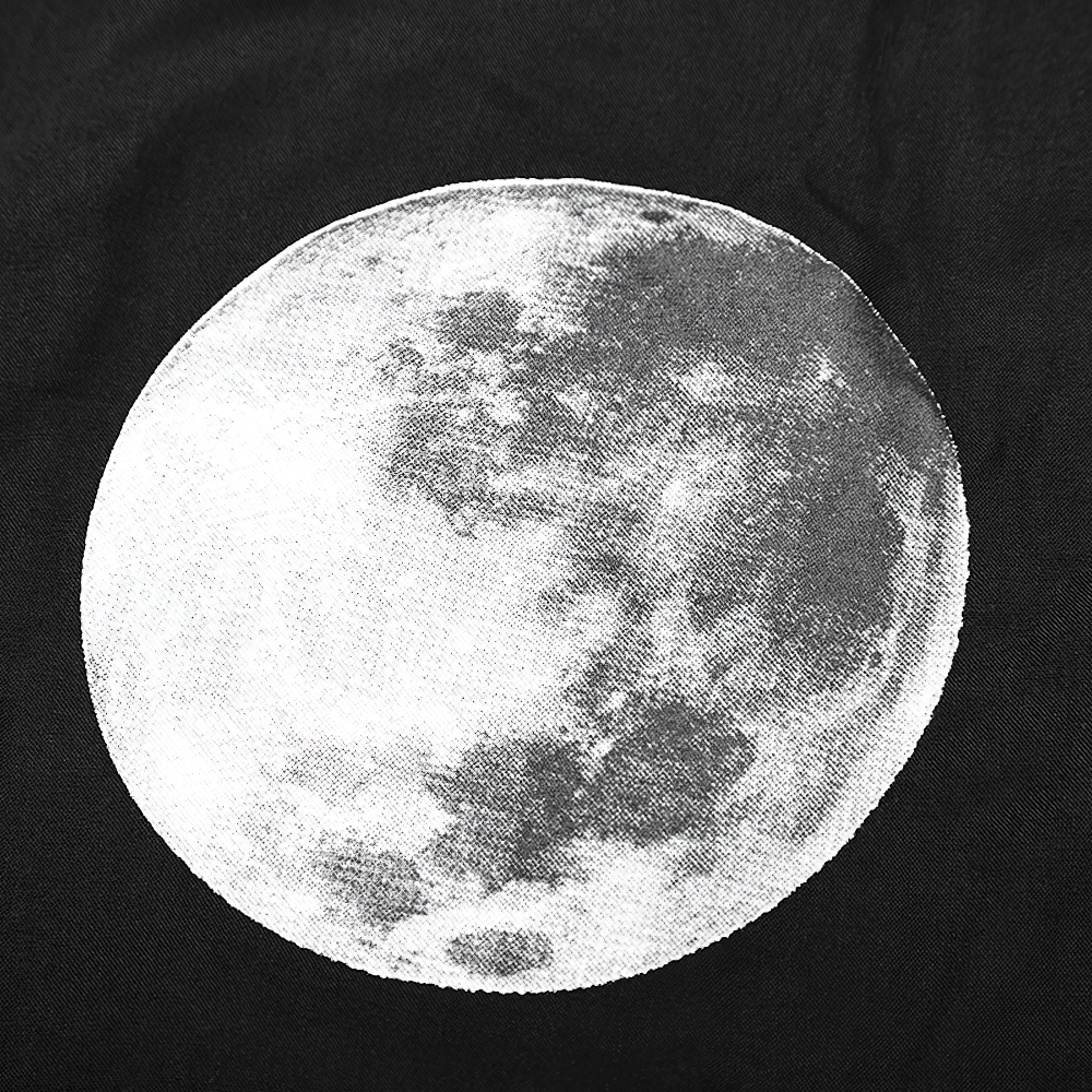 Close-up of a stunning moon graphic on a black fabric background, showcasing celestial elegance.