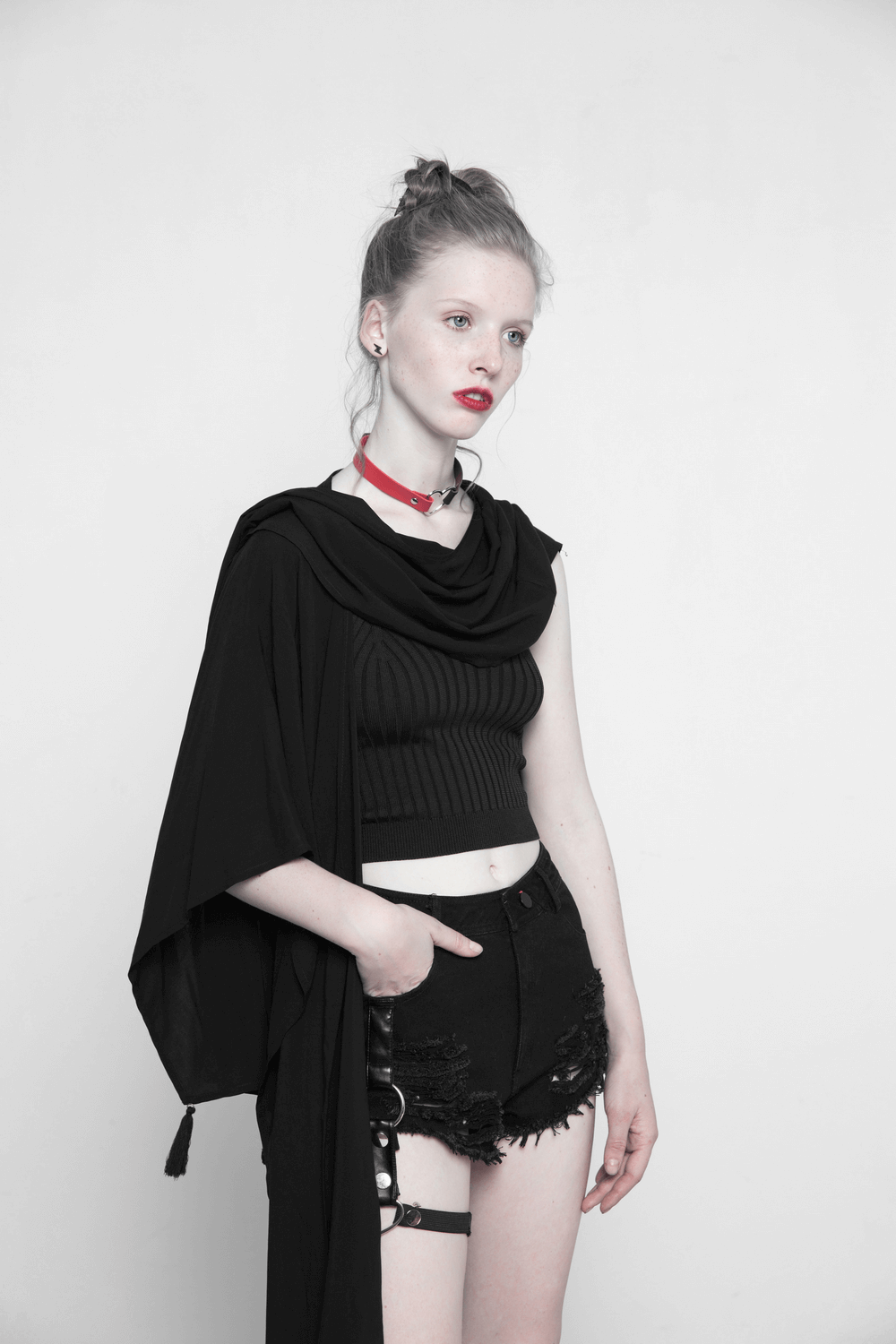 Elegant black shawl draped over a model wearing a cropped top and shorts, showcasing a chic, mysterious style.