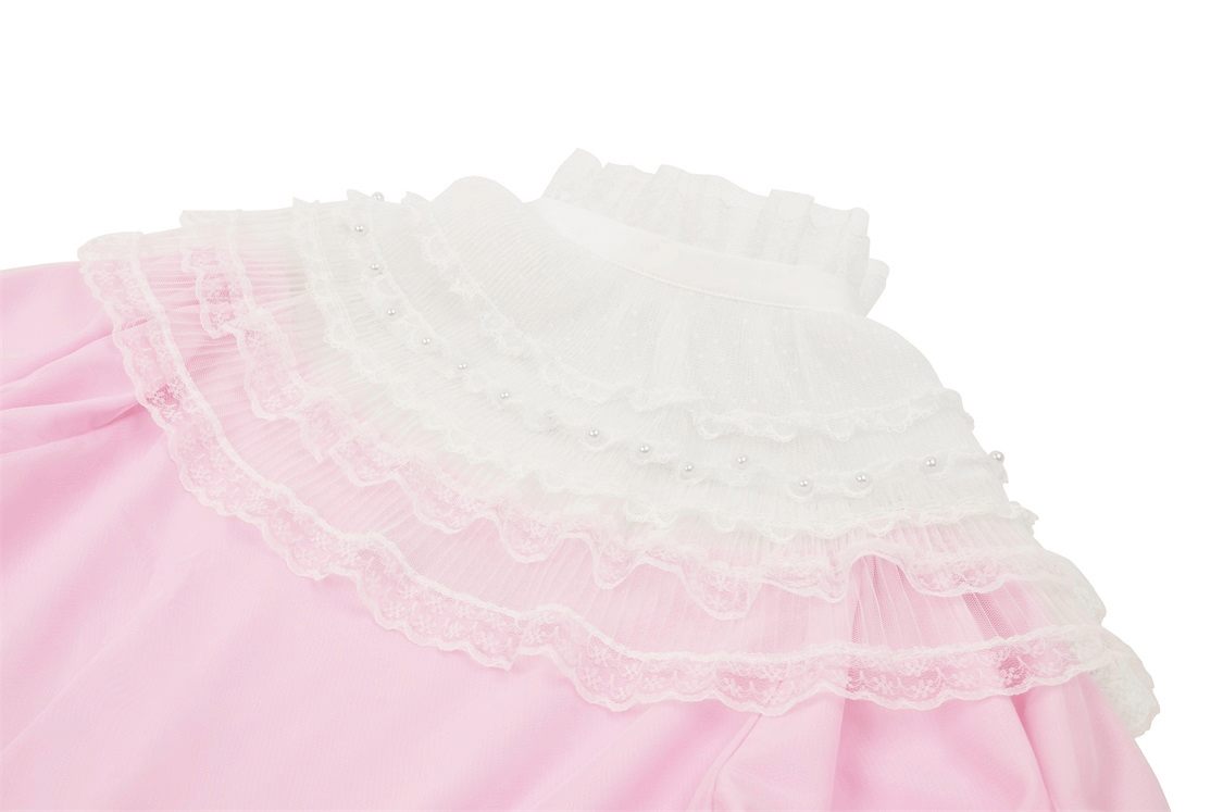 Close-up of elegant pink dress with delicate white lace detailing and ruffled collar for a chic look.