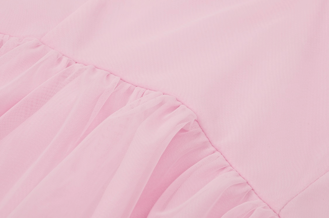 Close-up of soft pink fabric with delicate lace ruffles, showcasing elegance and sophistication.