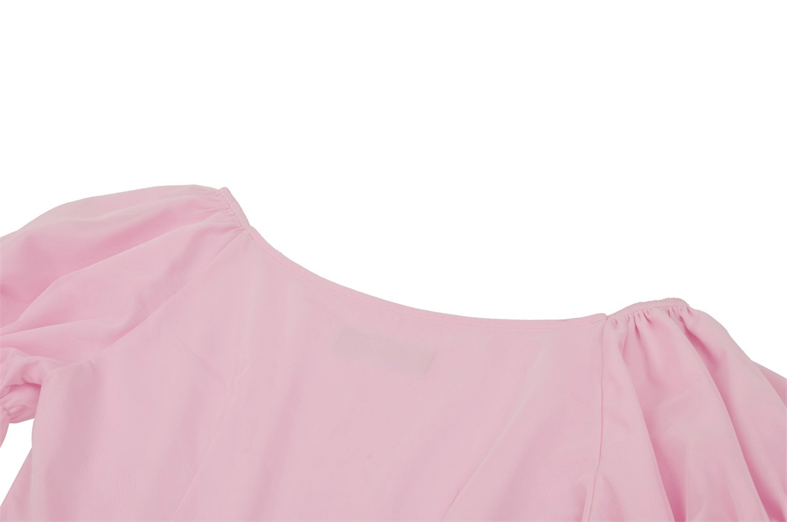 Elegant pink dress detail featuring soft fabric and delicate lace on the neckline.