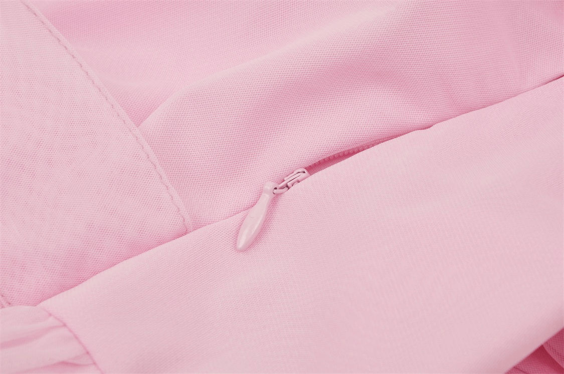 Close-up of a pink dress zipper detail, showcasing the elegant fabric and chic design for a sophisticated look.