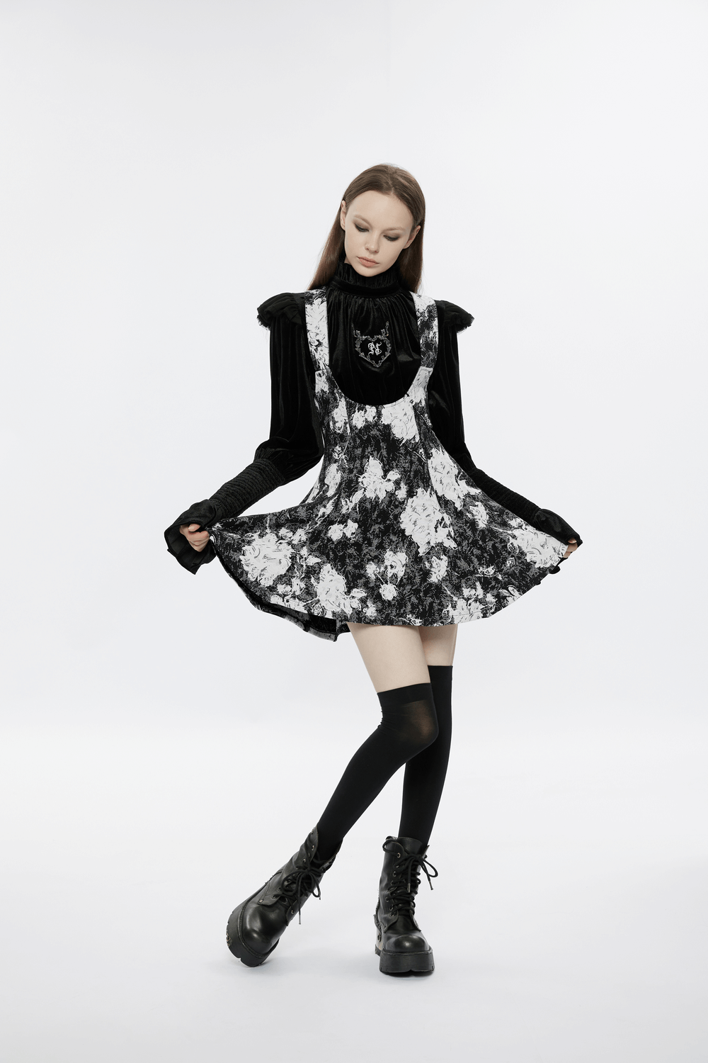 Elegant black and white floral dress with a flared skirt and stylish boots, exuding gothic charm.