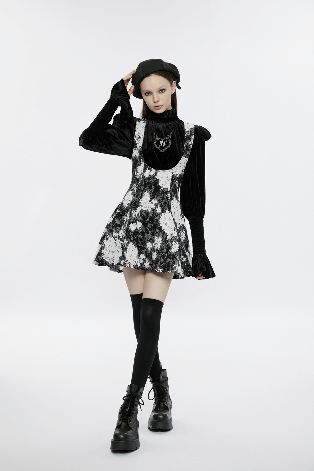 Elegant punk gothic dress with dark floral pattern, worn by model with knee-high socks and chunky boots.