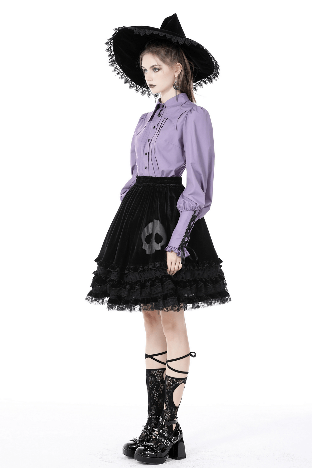 Elegant purple blouse with ruffled sleeves styled with a black skull skirt and wide-brimmed hat, perfect for a chic look.