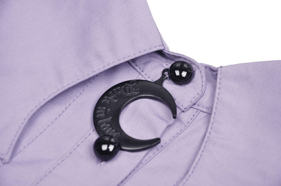 Close-up of the elegant purple blouse featuring a chic black crescent moon button and stylish pin-tucked detailing.