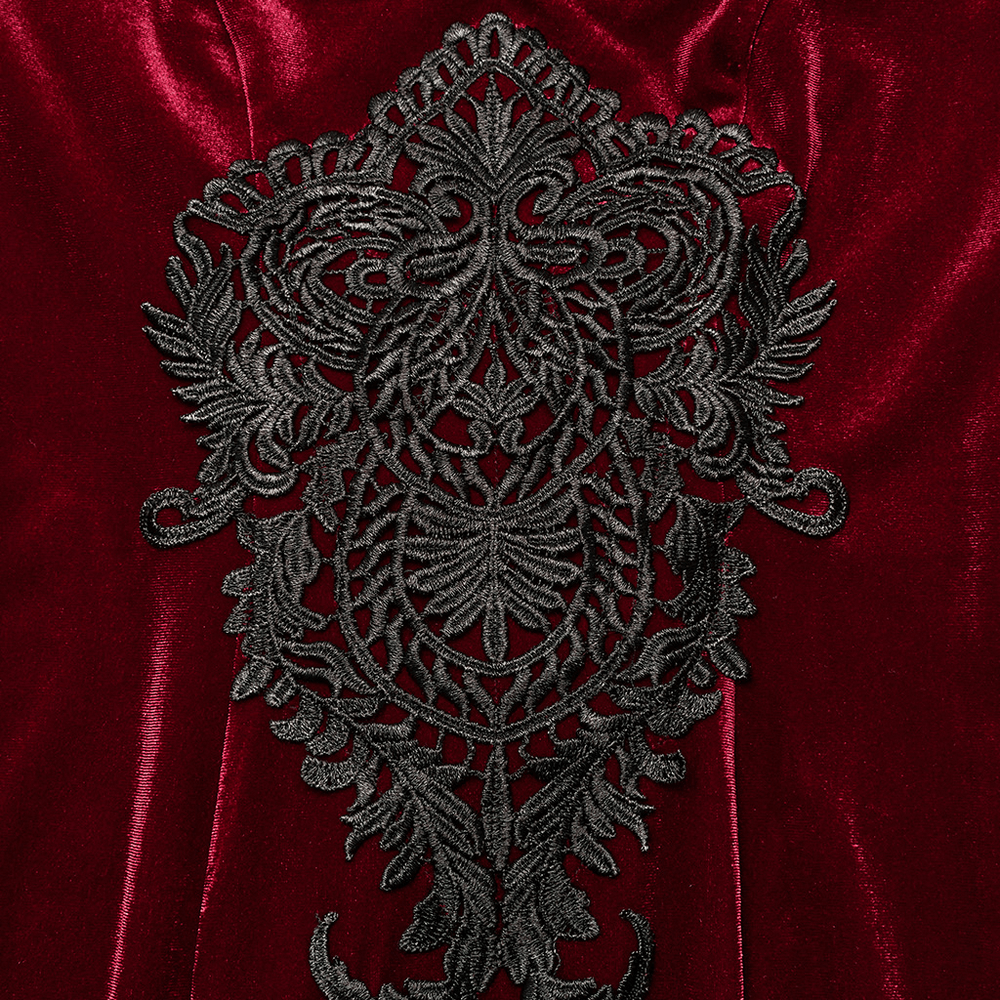 Close-up of luxurious black lace decal on red velvet dress, showcasing intricate Gothic design and opulent details.