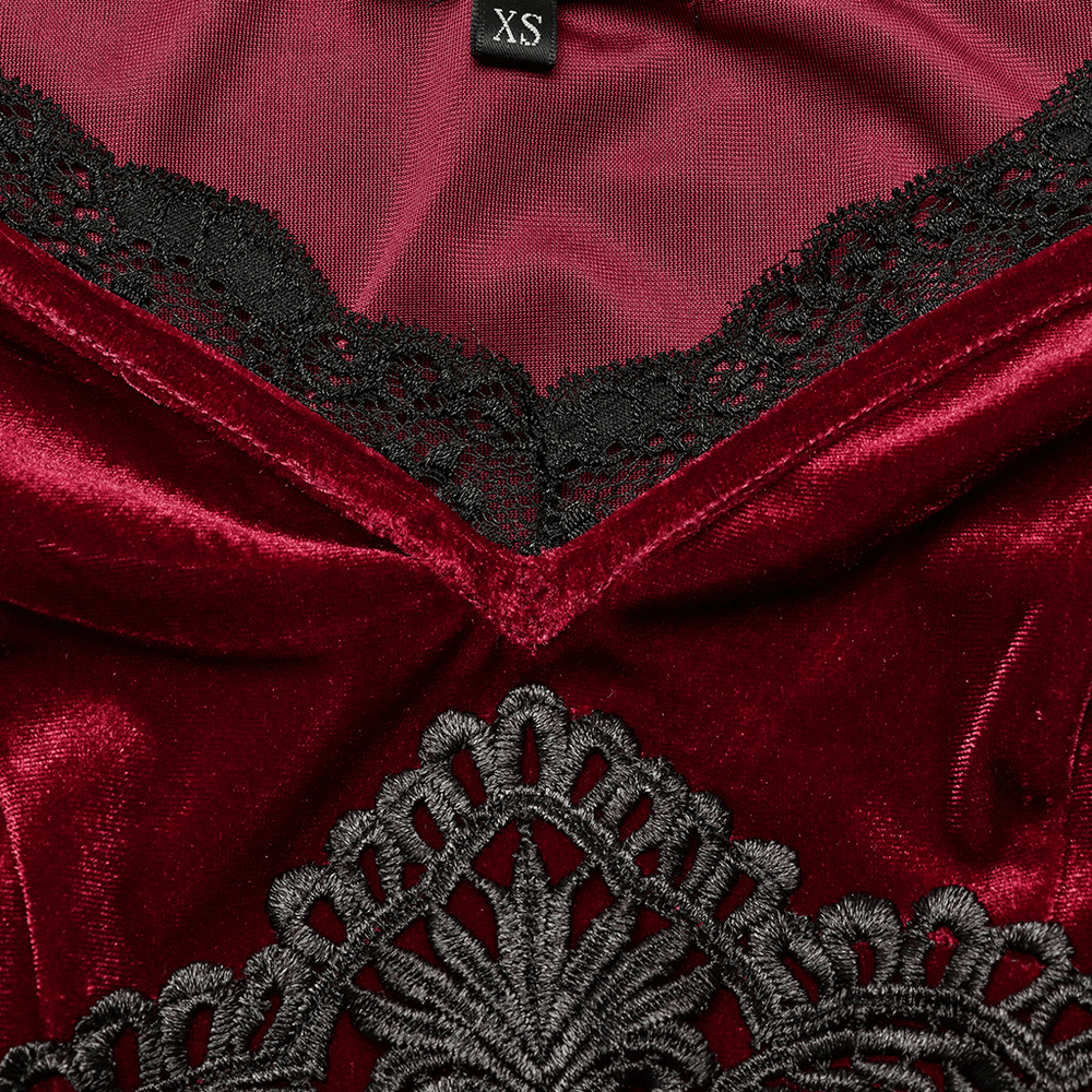 Close-up of elegant red velvet gothic dress with intricate black lace accents and beautiful decal detail.