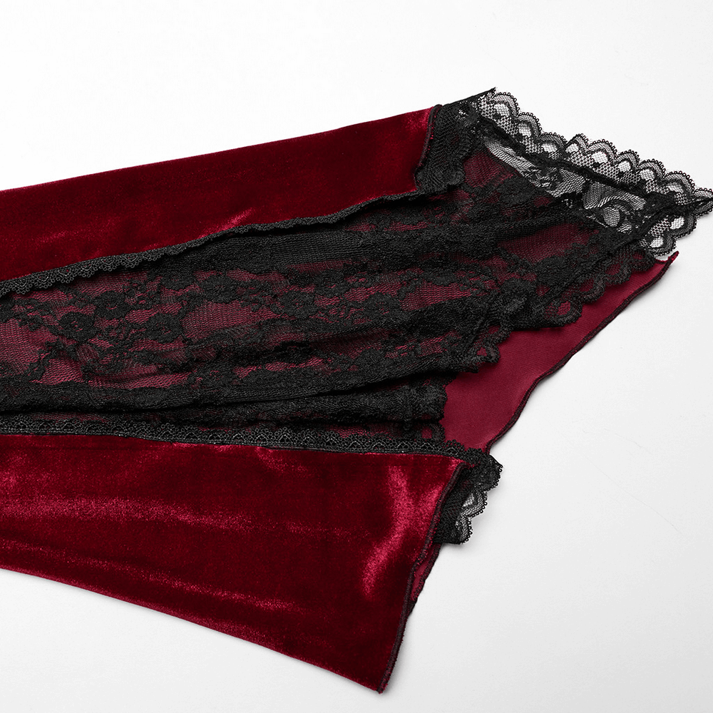 Close-up of luxurious red velvet fabric featuring intricate black lace detailing and elegant scalloped edges.