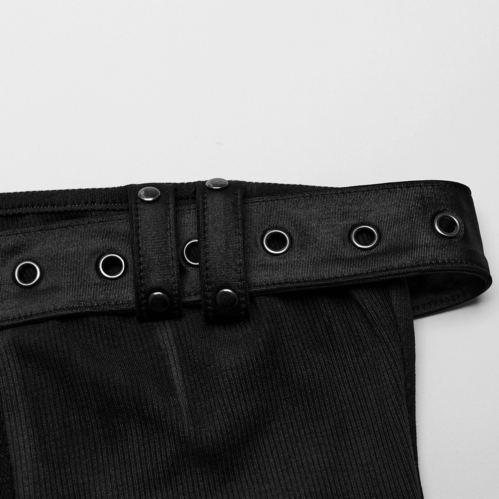 Close-up of sleek black ribbed pants featuring a stylish belt with metal eyelets and snap details.