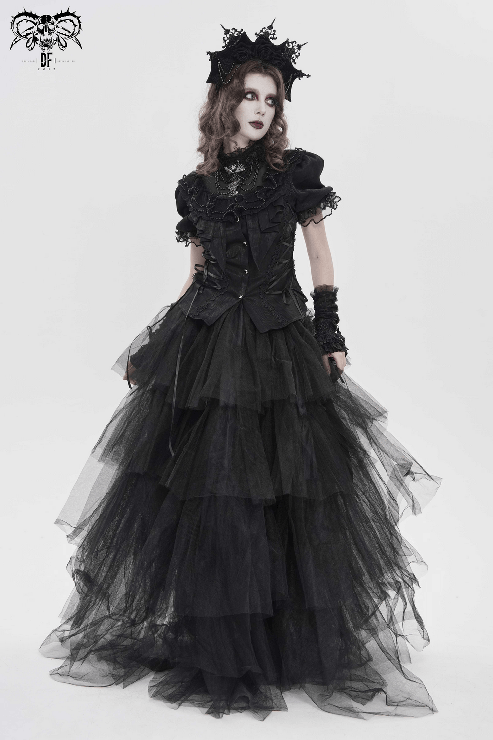 Elegant Ruffle Blouse with Sheer Yoke and Lace-Up Sides displayed on a model in a dramatic black ensemble.
