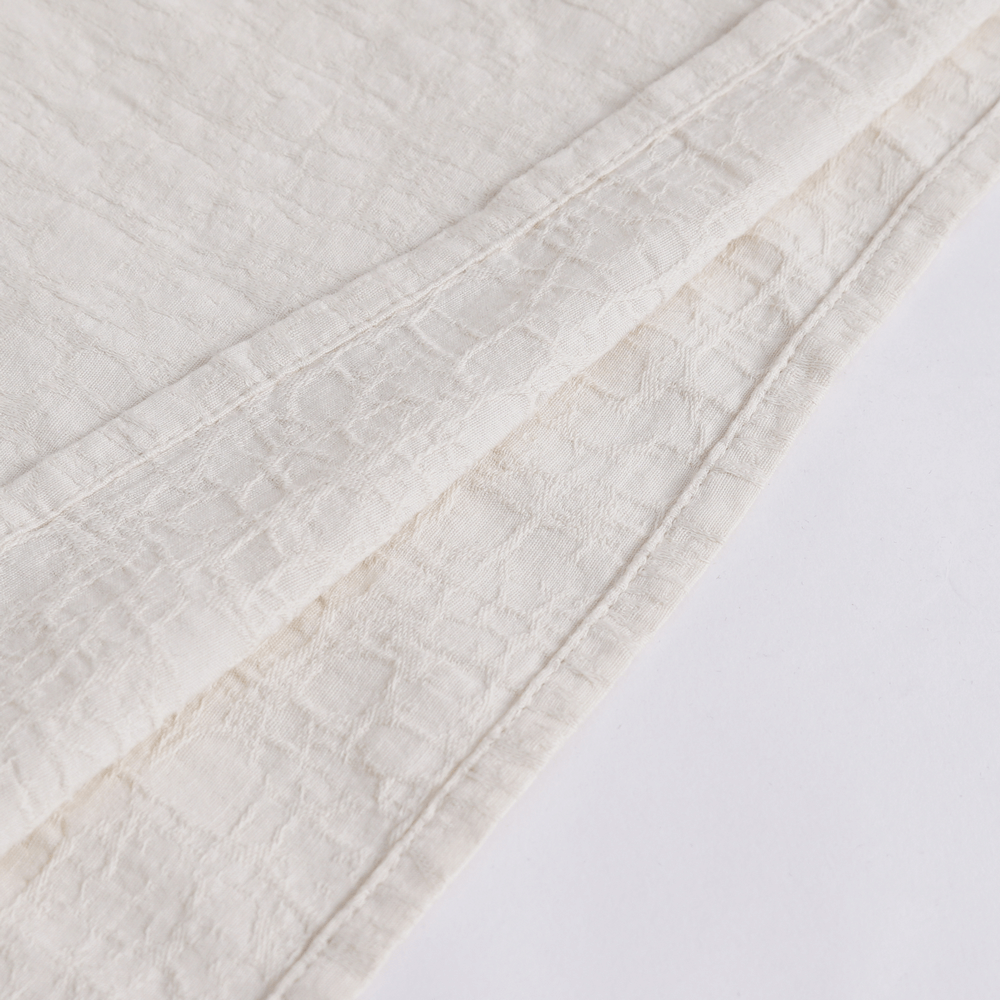 Close-up of elegant vintage ruffled cotton shirt showcasing textured fabric and delicate detailing.