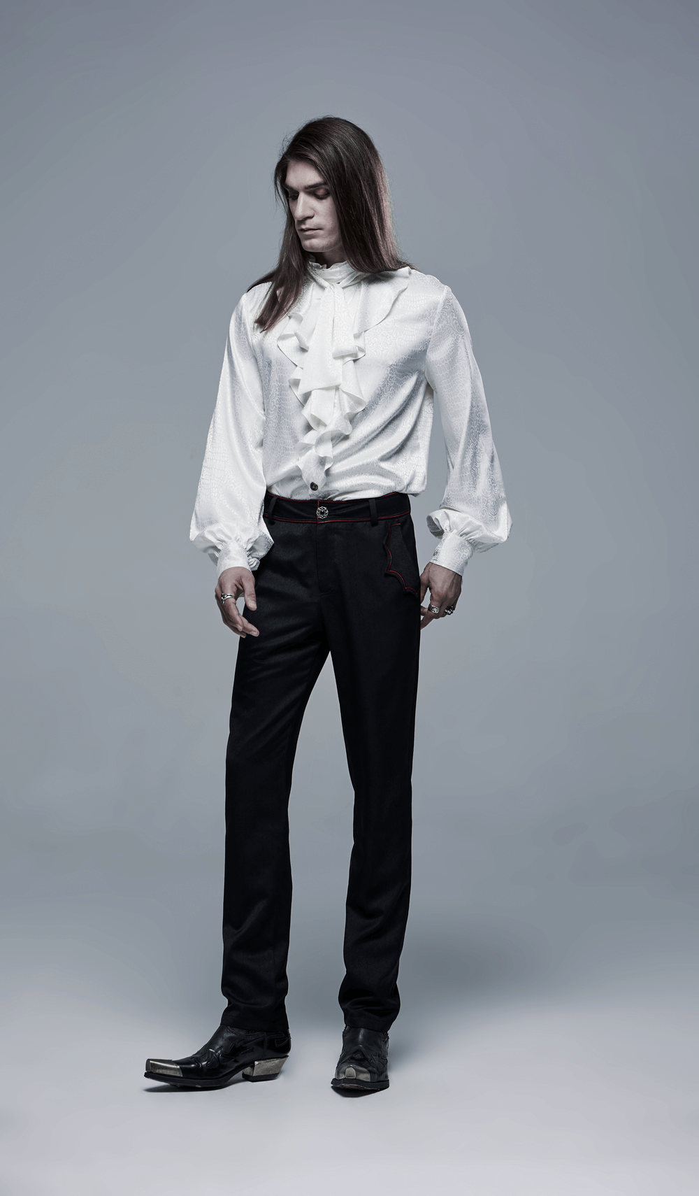 Stylish model wearing an elegant ruffled gothic blouse paired with black pants, exuding gothic sophistication.