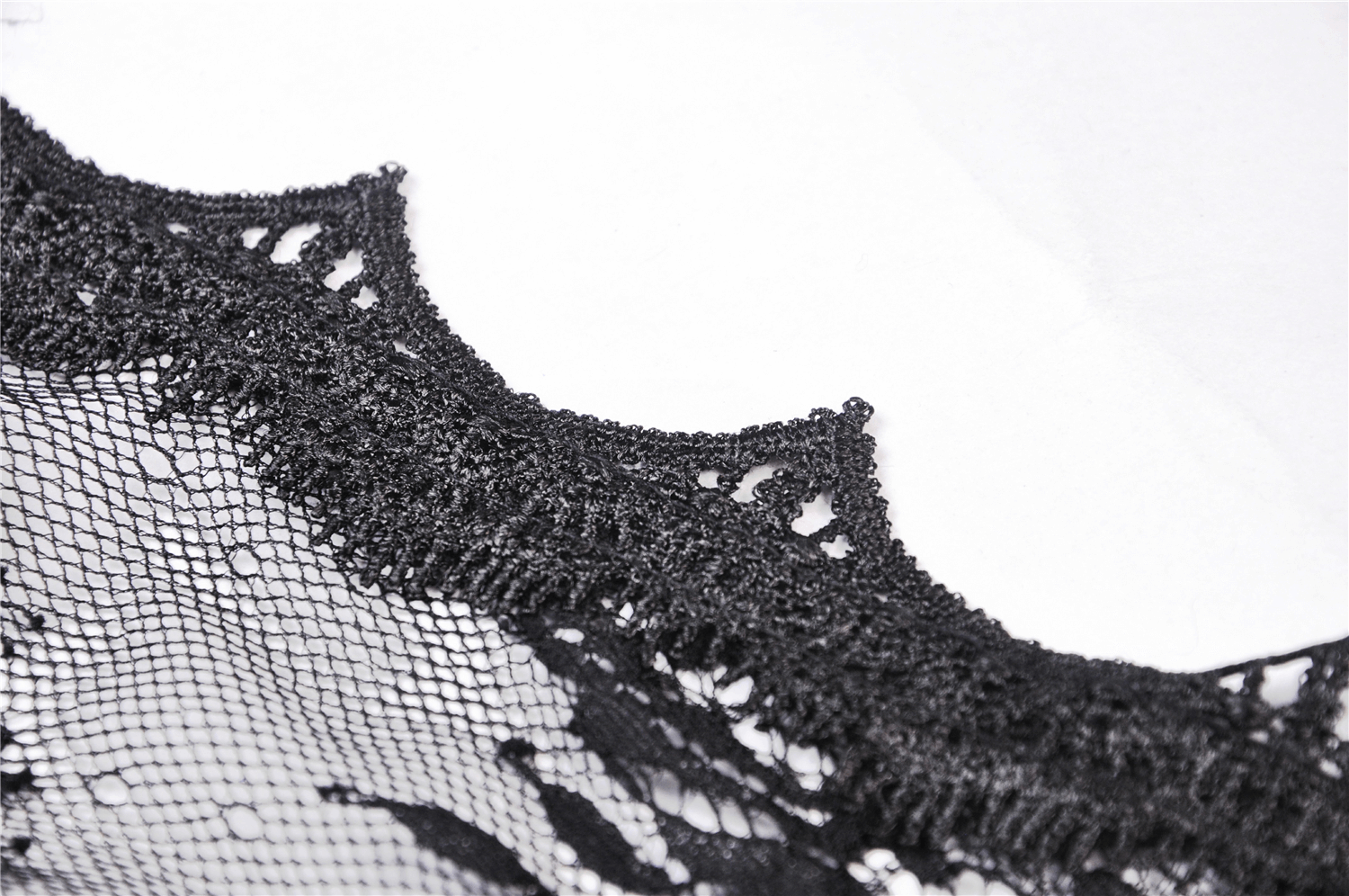 Close-up of elegant black lace with intricate detailing for women’s flare sleeve cape.