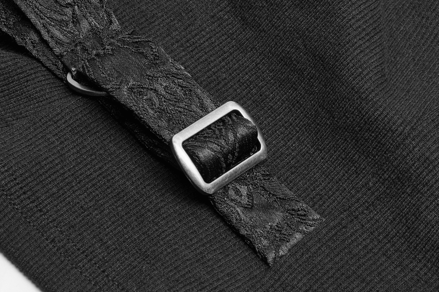 Close-up of elegant black band with silver buckle on steampunk waistcoat, showcasing intricate design details.