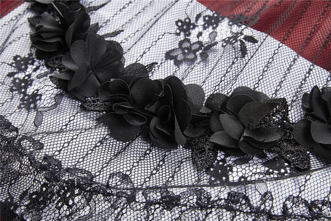 Close-up of elegant black lace with floral appliqués on a red and black Victorian-inspired skirt.