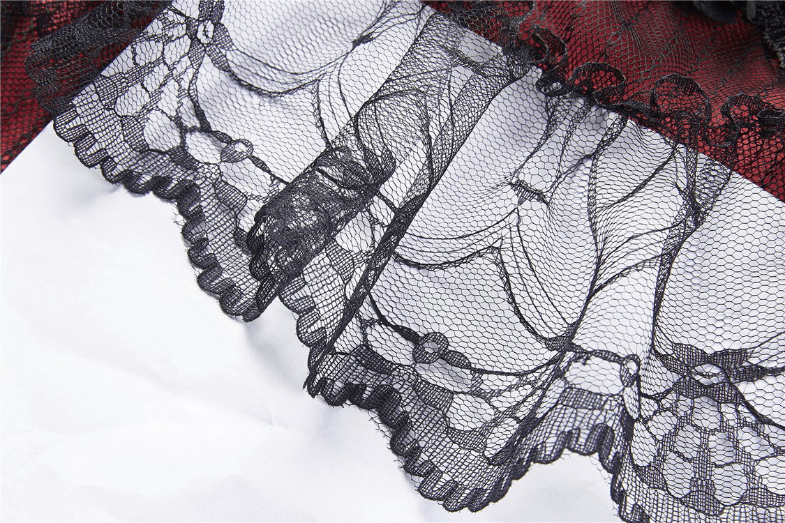 Close-up of intricate black lace trim cascading over a rich red fabric, perfect for a Victorian-inspired outfit.