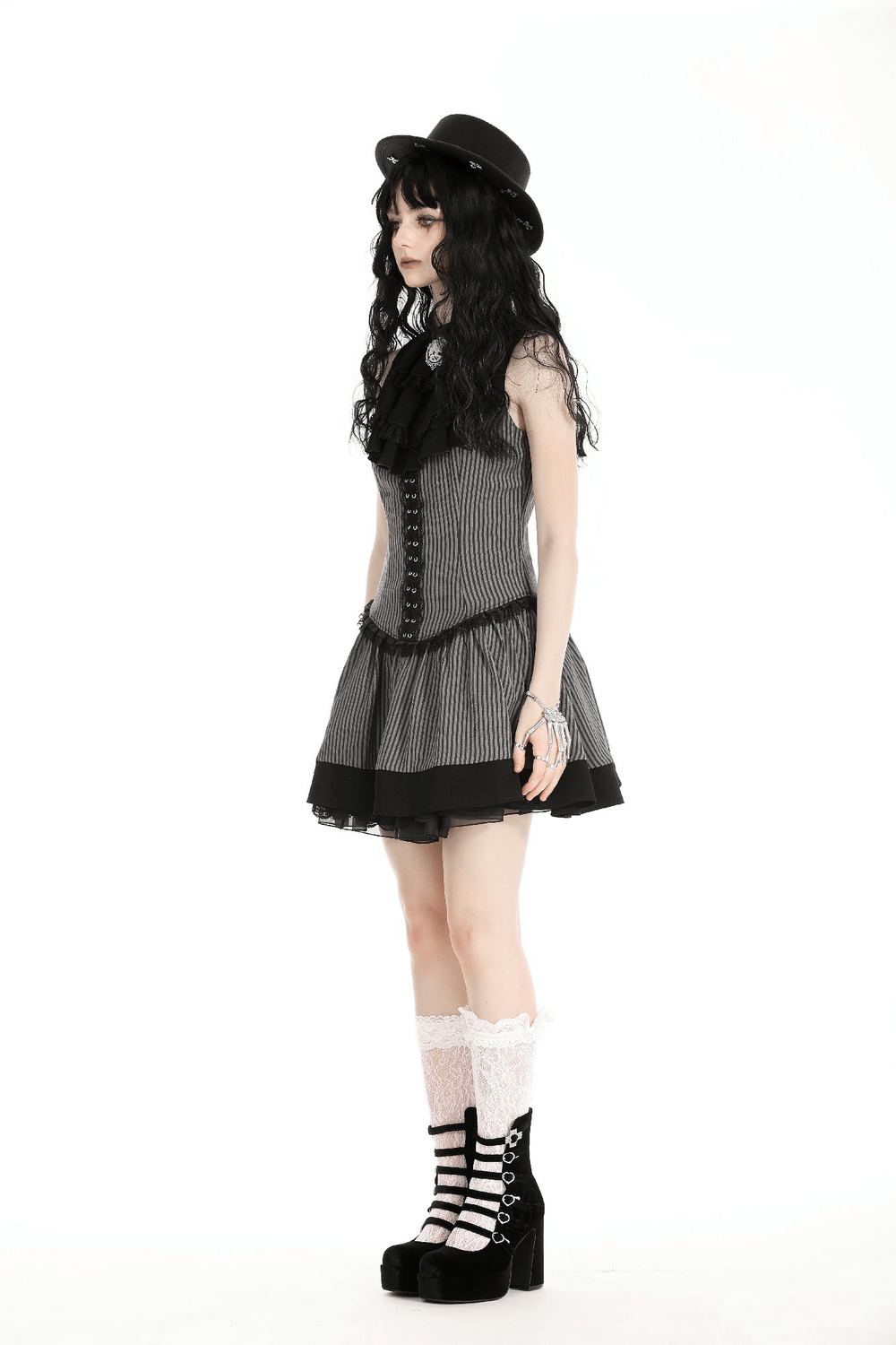 Elegant gothic-style sleeveless striped dress with ruffles and brooch accent, paired with stylish accessories.