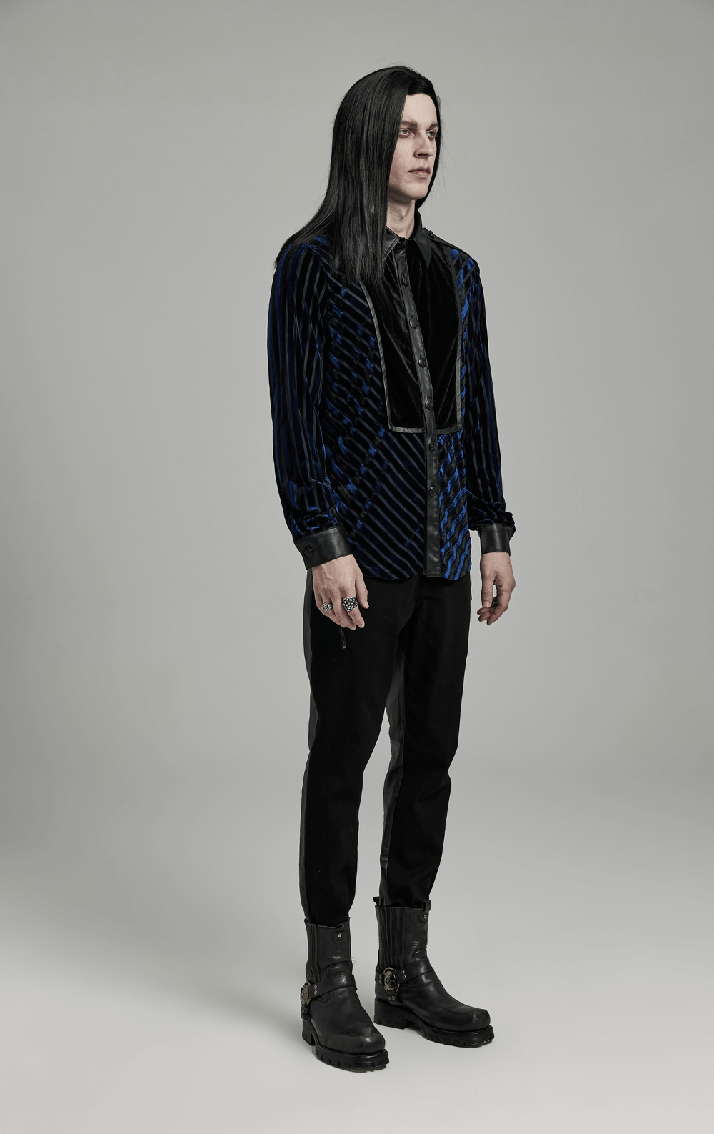 Stylish man in elegant striped velvet and rubberized men's shirt, showcasing modern fashion and edgy sophistication.