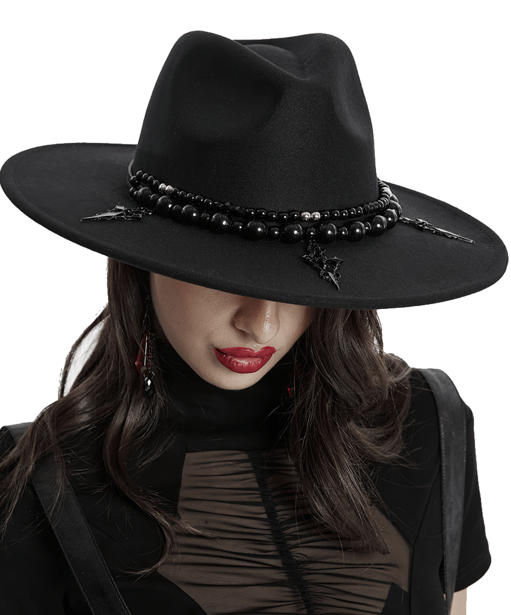 Elegant black suede wide brim hat with Gothic pearl details and Satan's cross accents, worn with a stylish outfit.