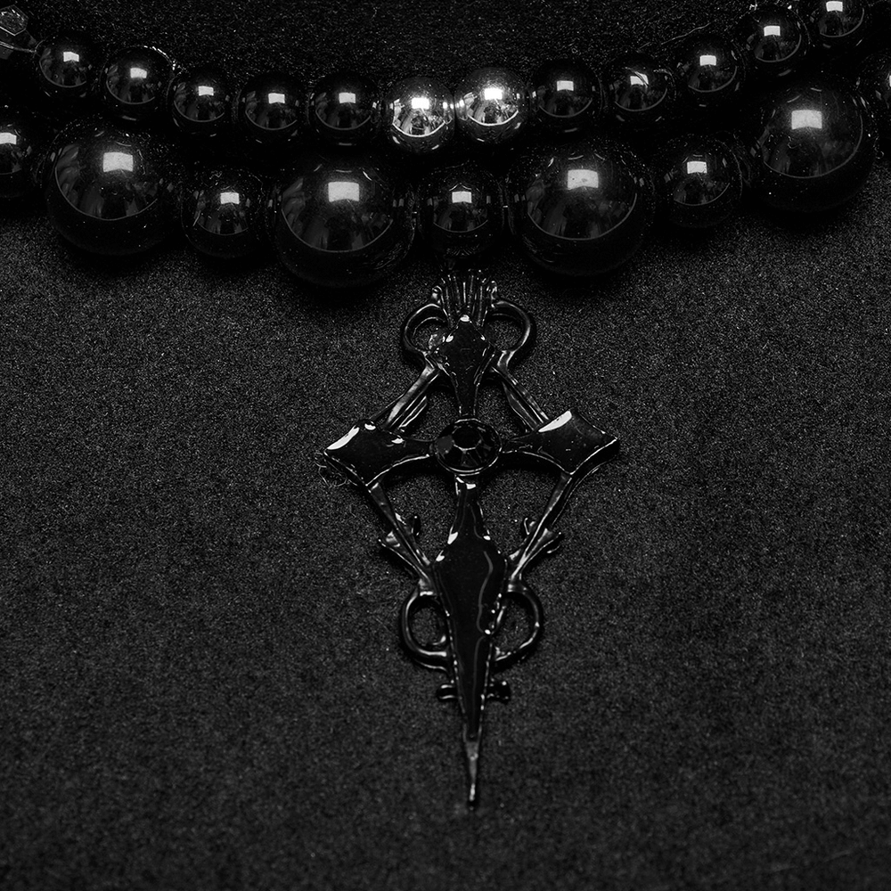 Close-up of a striking Satan's cross pendant on a gothic beaded necklace, exuding dark elegance.