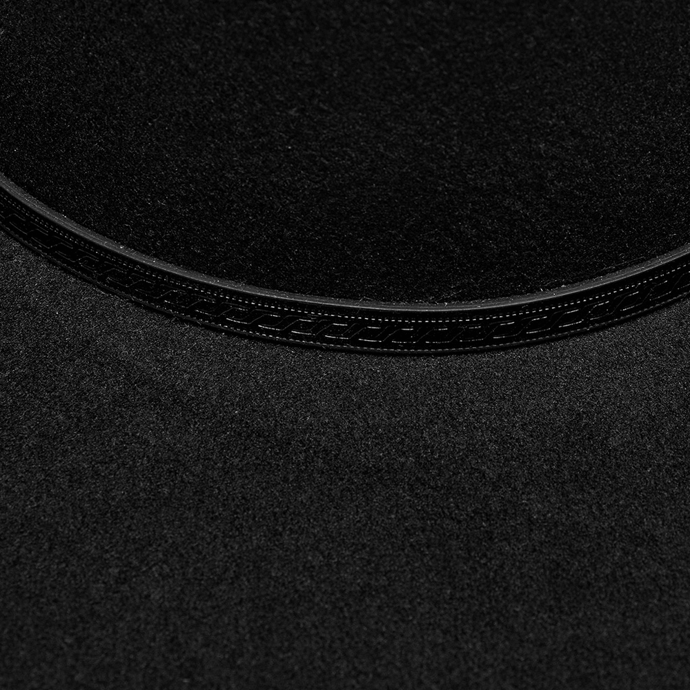 Close-up of the elegant suede texture and intricate black embossed loop on a gothic wide-brim hat.