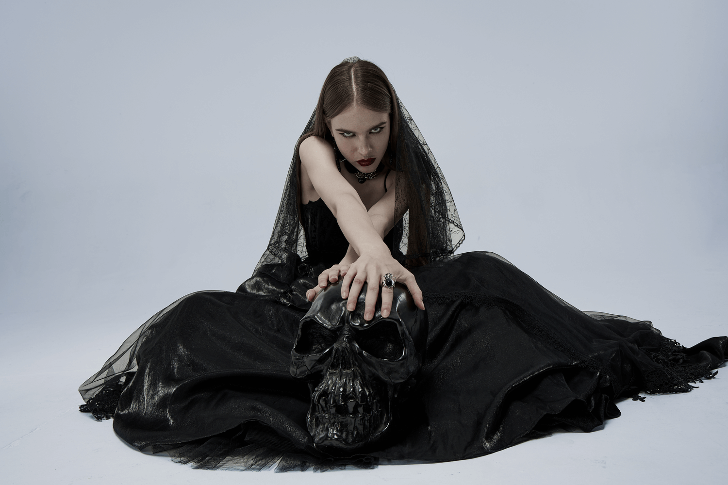 Gothic bridal gown model with skull, showcasing elegance and dark allure in tulle and velvet fabric.
