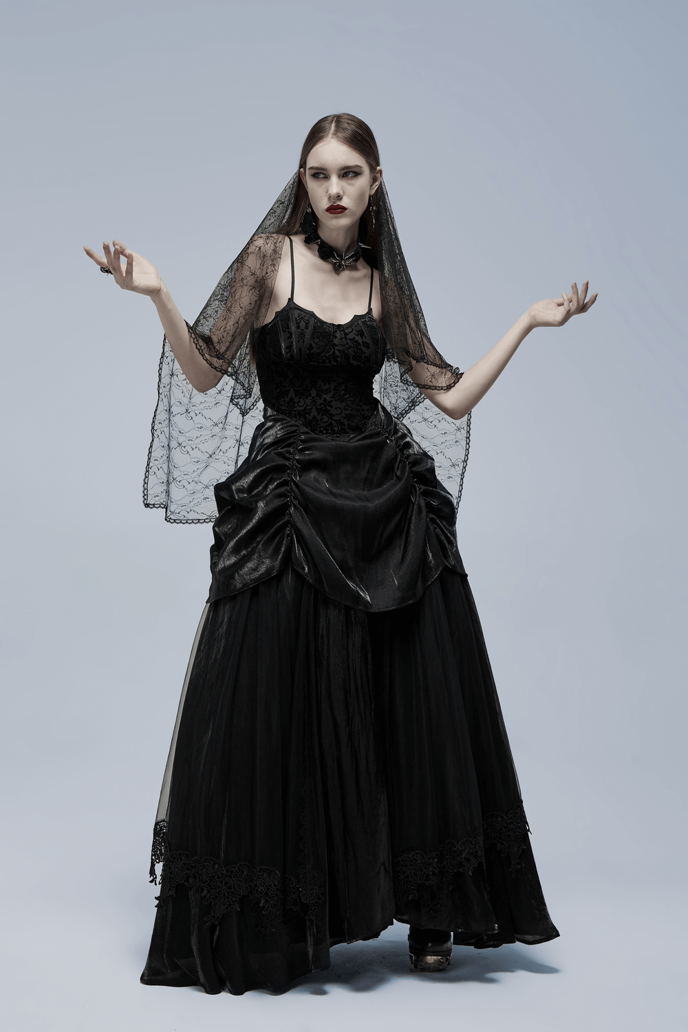 Elegant gothic bridal gown with tulle and velvet, featuring a dramatic silhouette and unique bat motif.