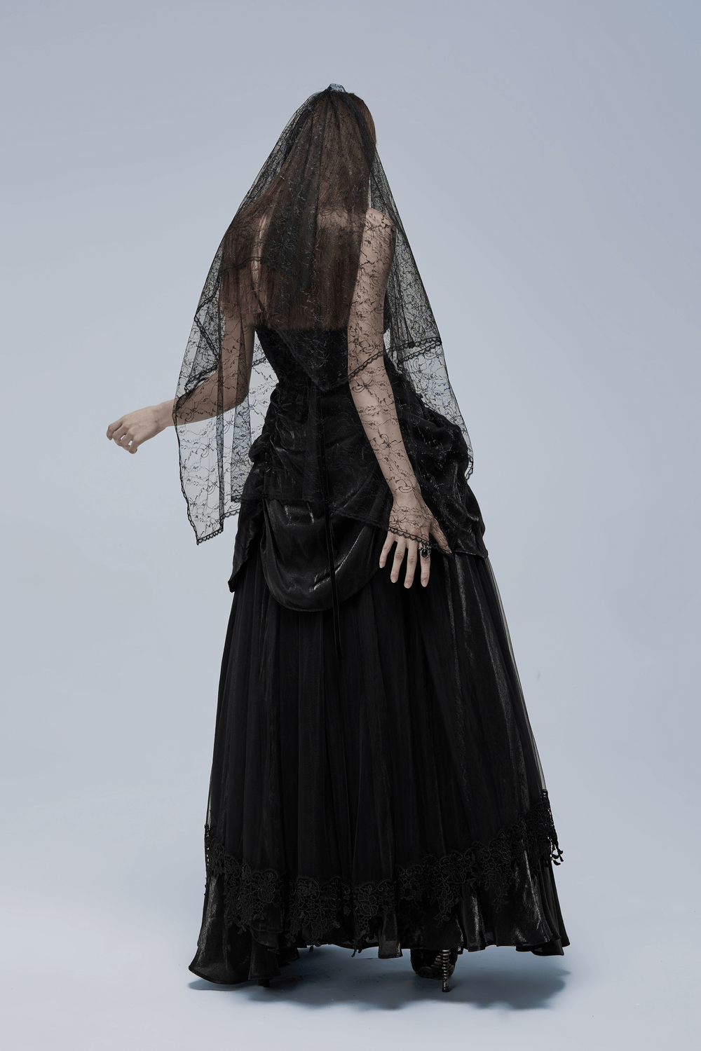 Back view of an elegant black gothic gown with intricate lace and a flowing veil, perfect for a dramatic bridal look.