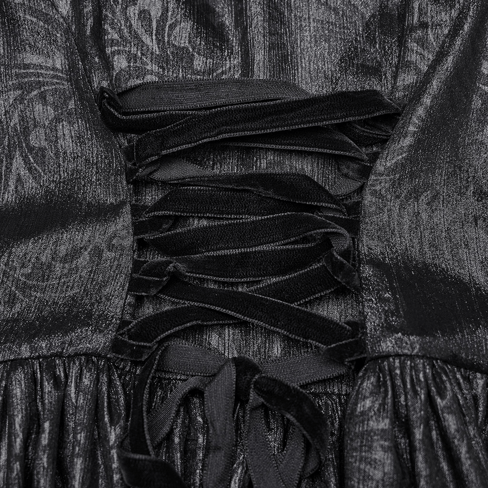 Close-up of the elegant black chiffon dress detailing with dramatic lacing and modern design elements.
