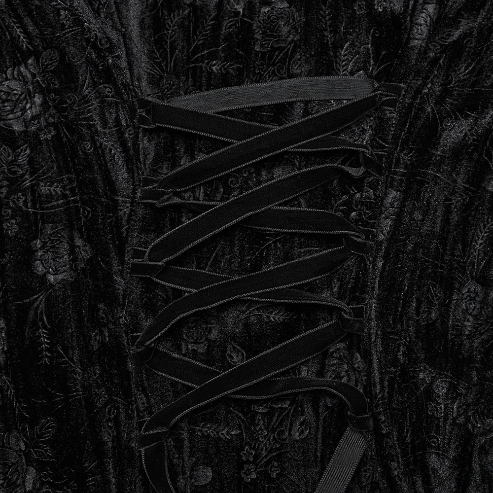 Close-up of elegant black velvet dress showing intricate lace-up detail with floral patterns and soft texture.