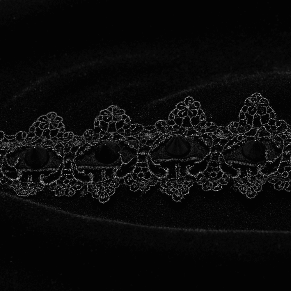 Close-up of intricate black lace detailing on an elegant velvet cloak, showcasing gothic charm.