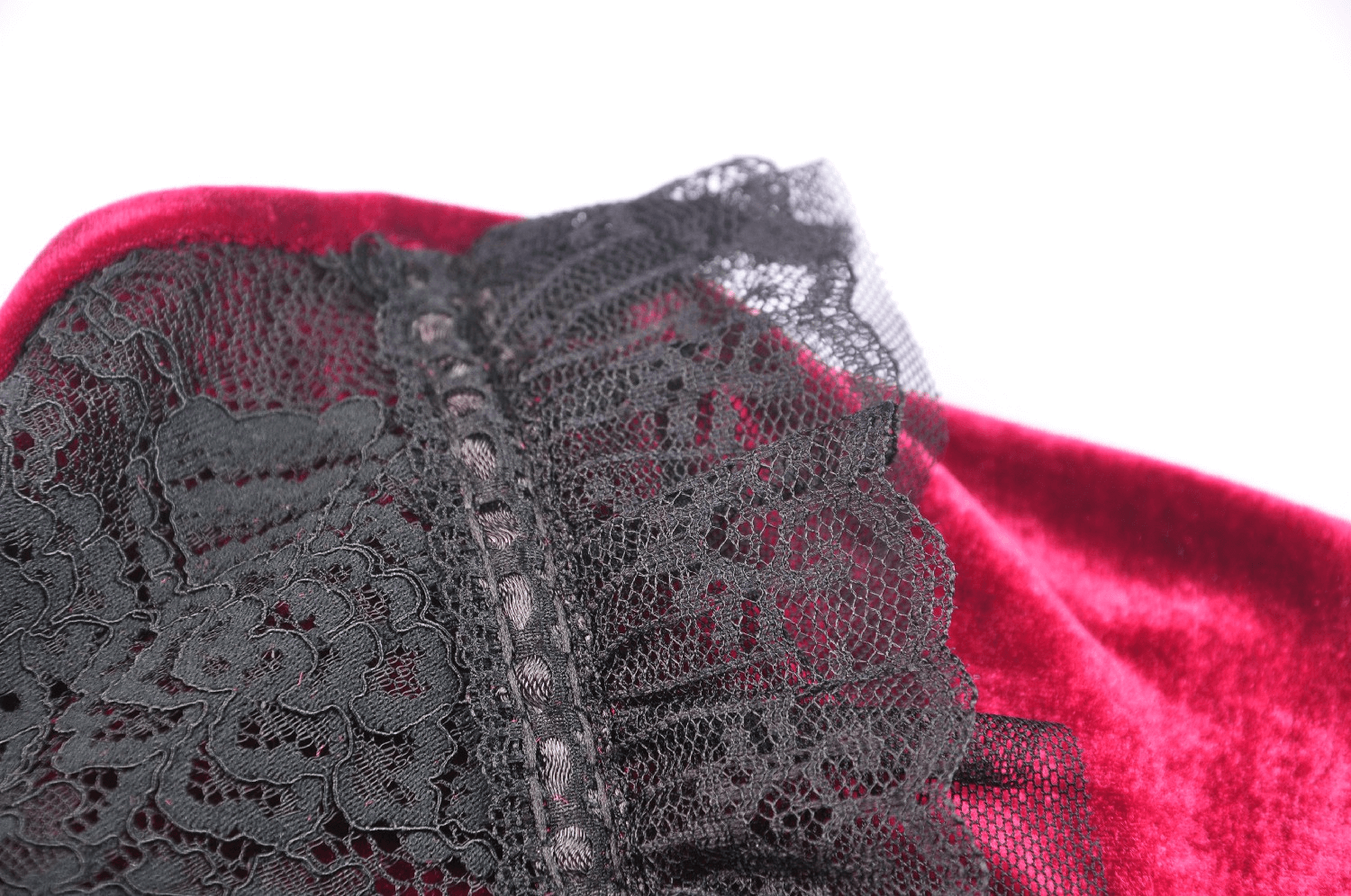 Close-up of black lace detail on elegant red velvet dress, adding Gothic Victorian romance.