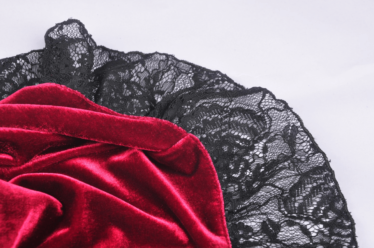 Close-up of luxurious red velvet fabric paired with intricate black lace, perfect for a gothic Victorian dress.