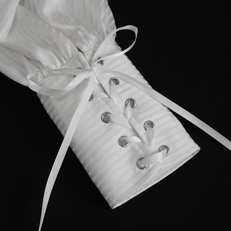 Close-up of pleated ruffle shirt cuff showcasing elegant lace-up detail and silk ribbon ties.