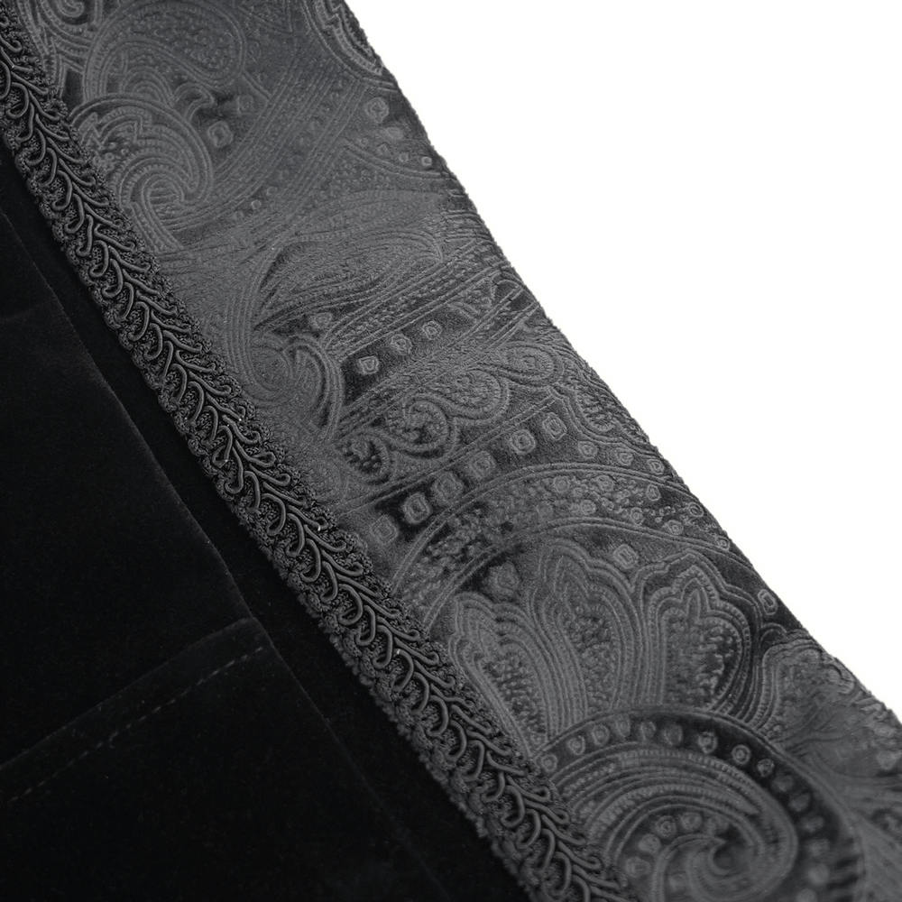 Close-up of luxurious black velvet fabric with intricate brocade pattern on the lapel of a Victorian tailcoat.