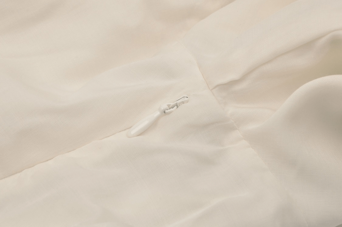 Close-up of the delicate lace detail and ivory fabric on an elegant vintage maxi dress.