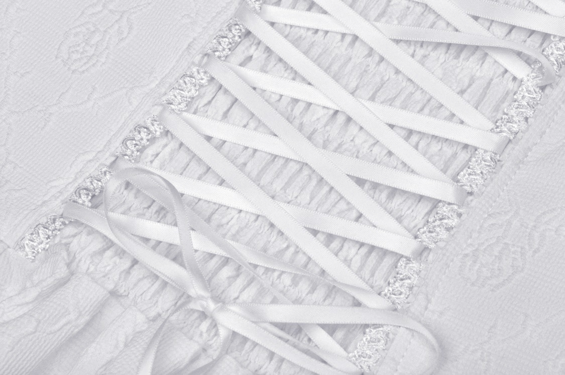 Close-up of white dress lace detailing with satin ribbons, perfect for bridal elegance and special occasions.