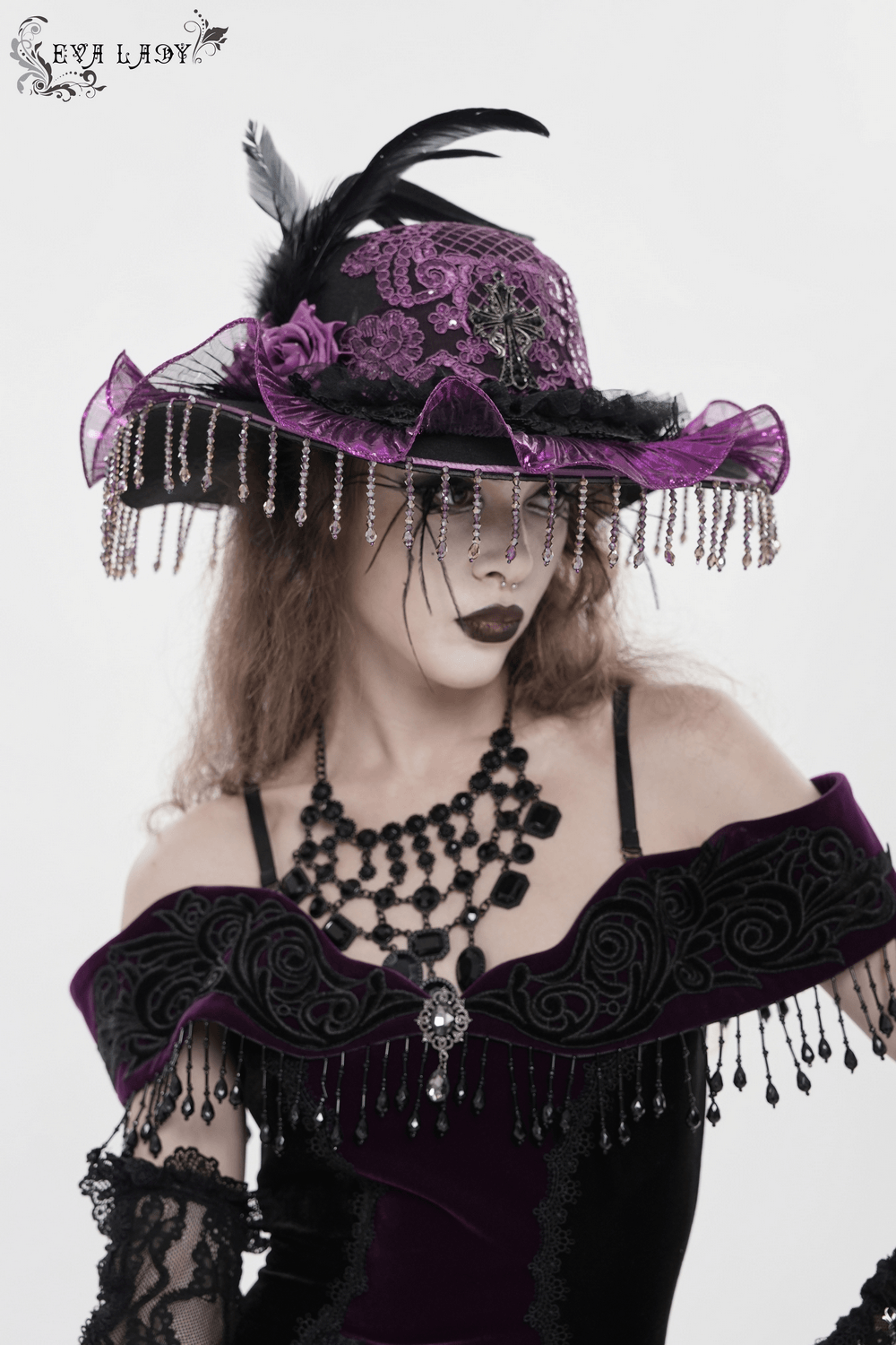 Elegant Wide Brim Hat with Lace Cross and Bead Fringe worn by a model, featuring purple accents and dramatic details.