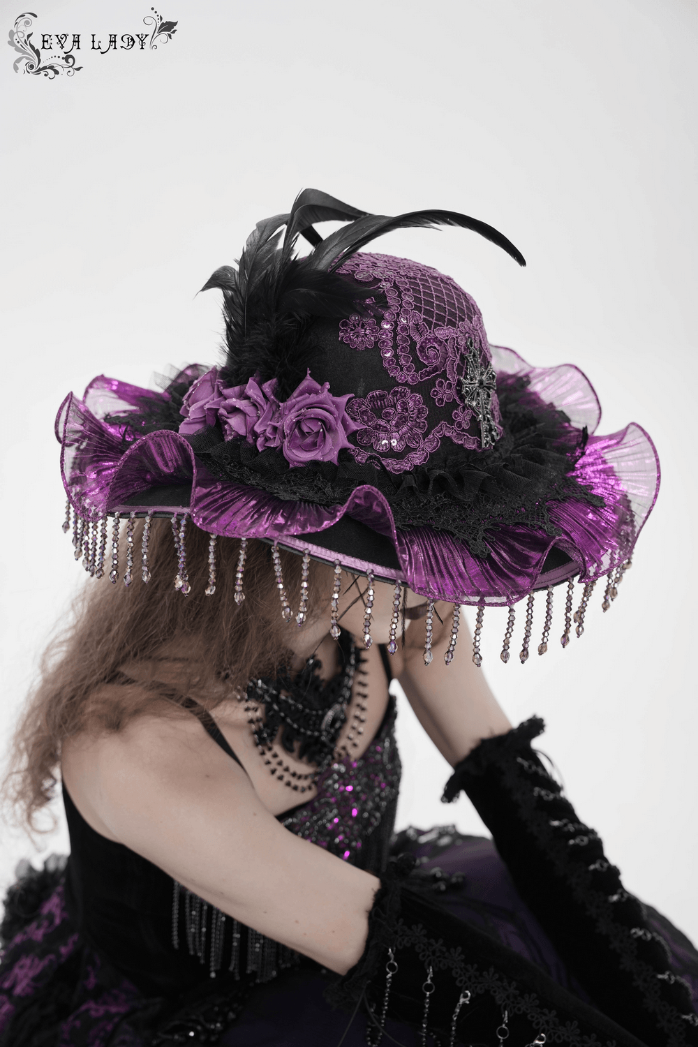 Elegant Wide Brim Hat with Lace Cross and Bead Fringe worn by a model, featuring purple lace, feathers, and beaded fringe.