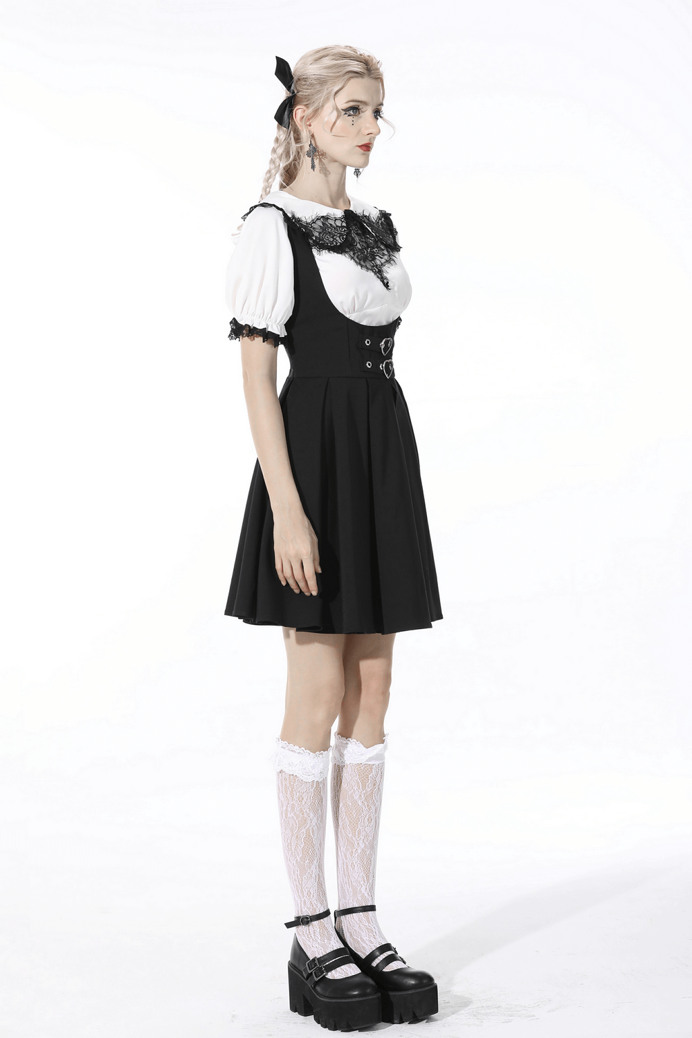 Stylish woman in a black dress with lace details, paired with knee-high socks and chunky black platform shoes.
