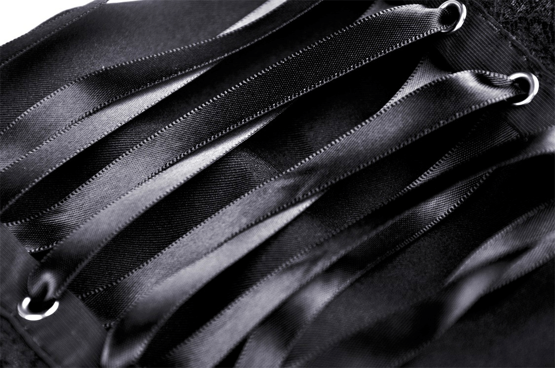Close-up of black dress belt detail with elegant satin ribbons, showcasing chic evening wear design.