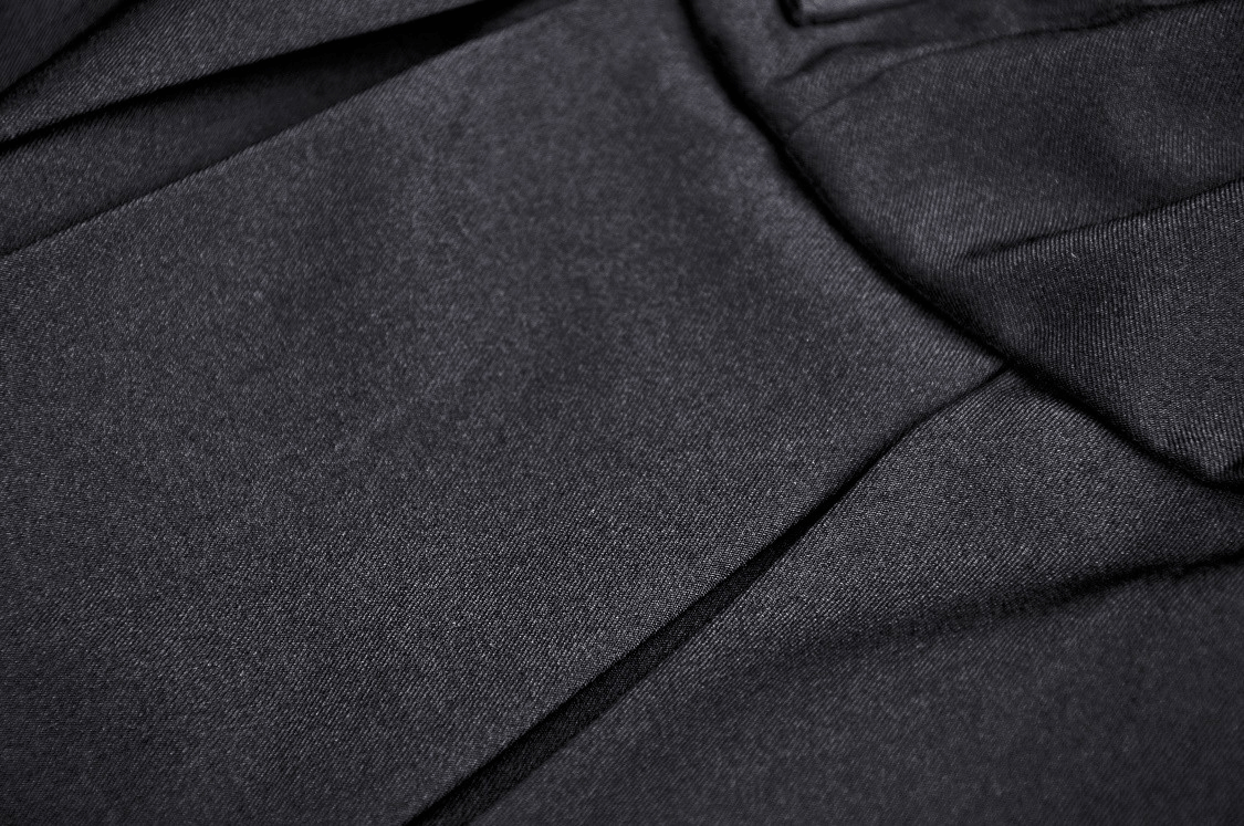 Close-up of the elegant black fabric texture from a chic women's dress with unique details.