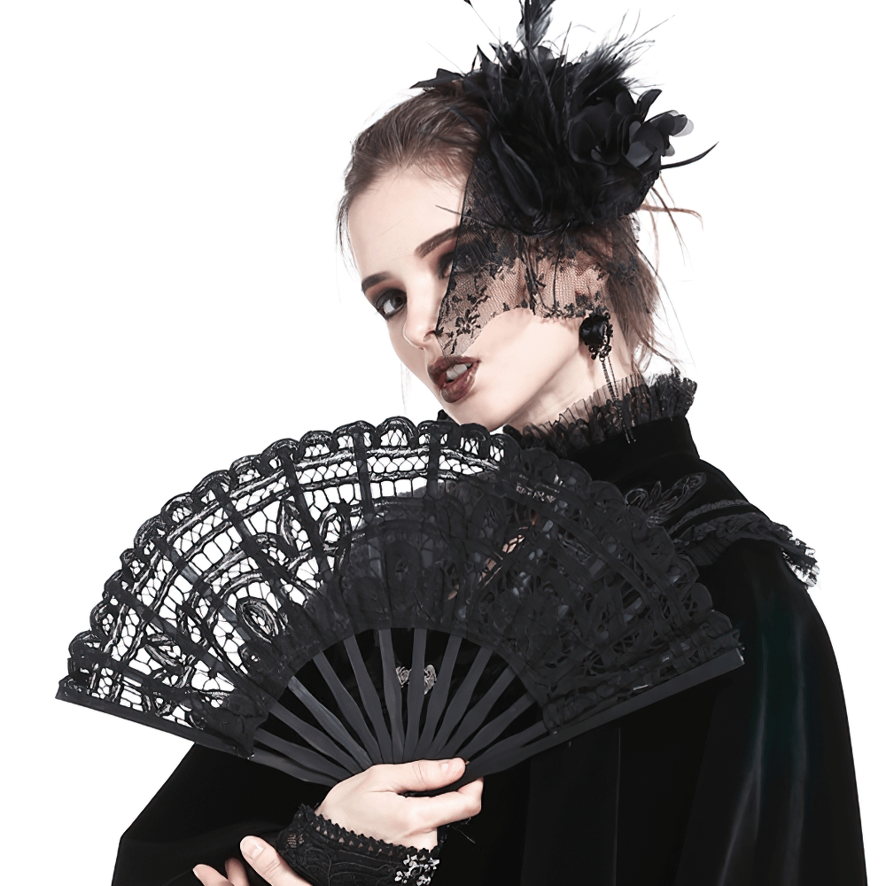 Elegant woman holding an intricate black lace fan, showcasing gothic style for evening events.