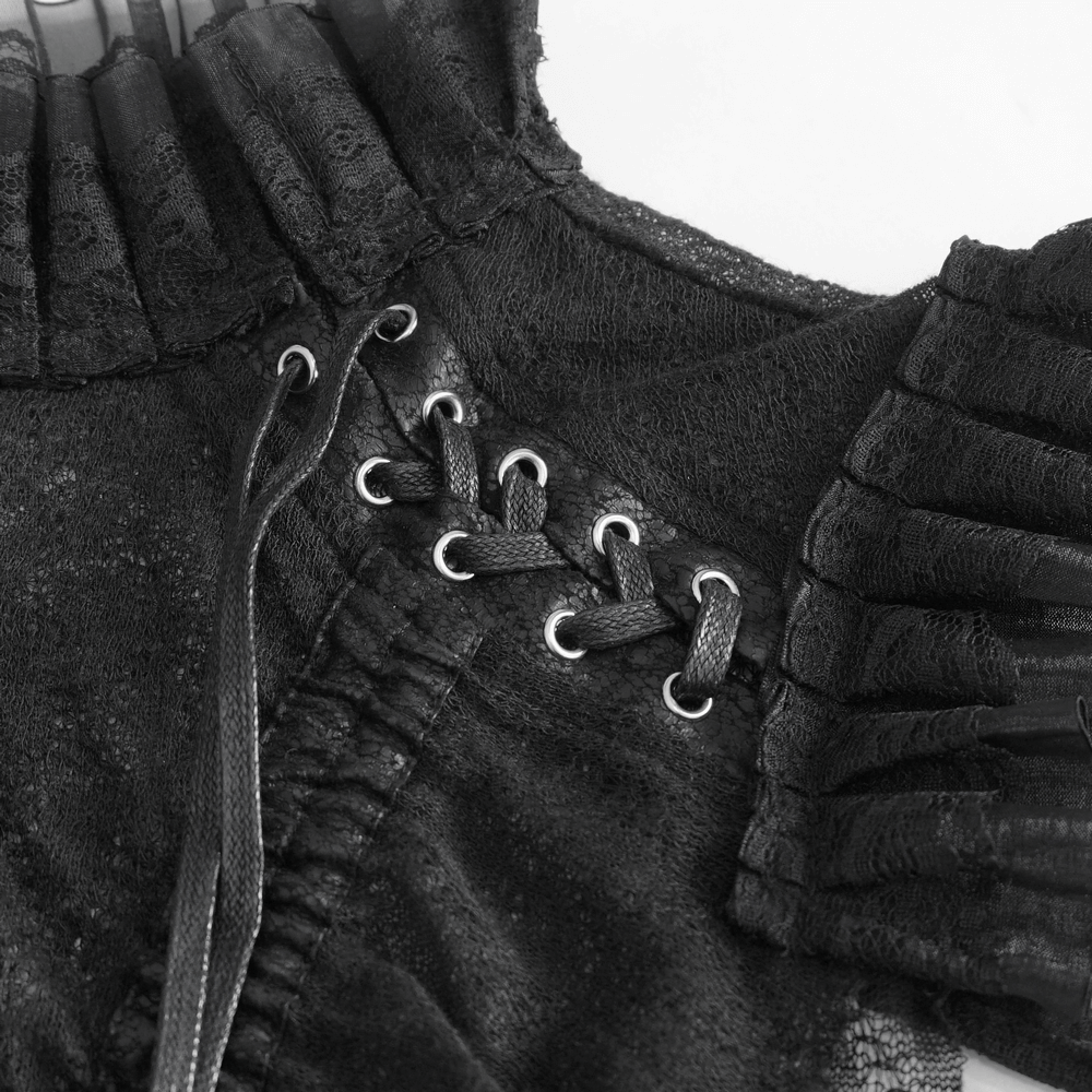 Close-up of elegant women's black sheer top showcasing ruffled details and lace accents.