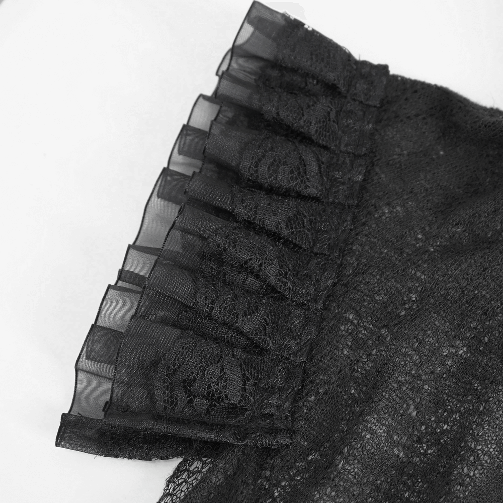 Close-up of ruffled lace detail on an elegant black sheer top, perfect for stylish occasions.