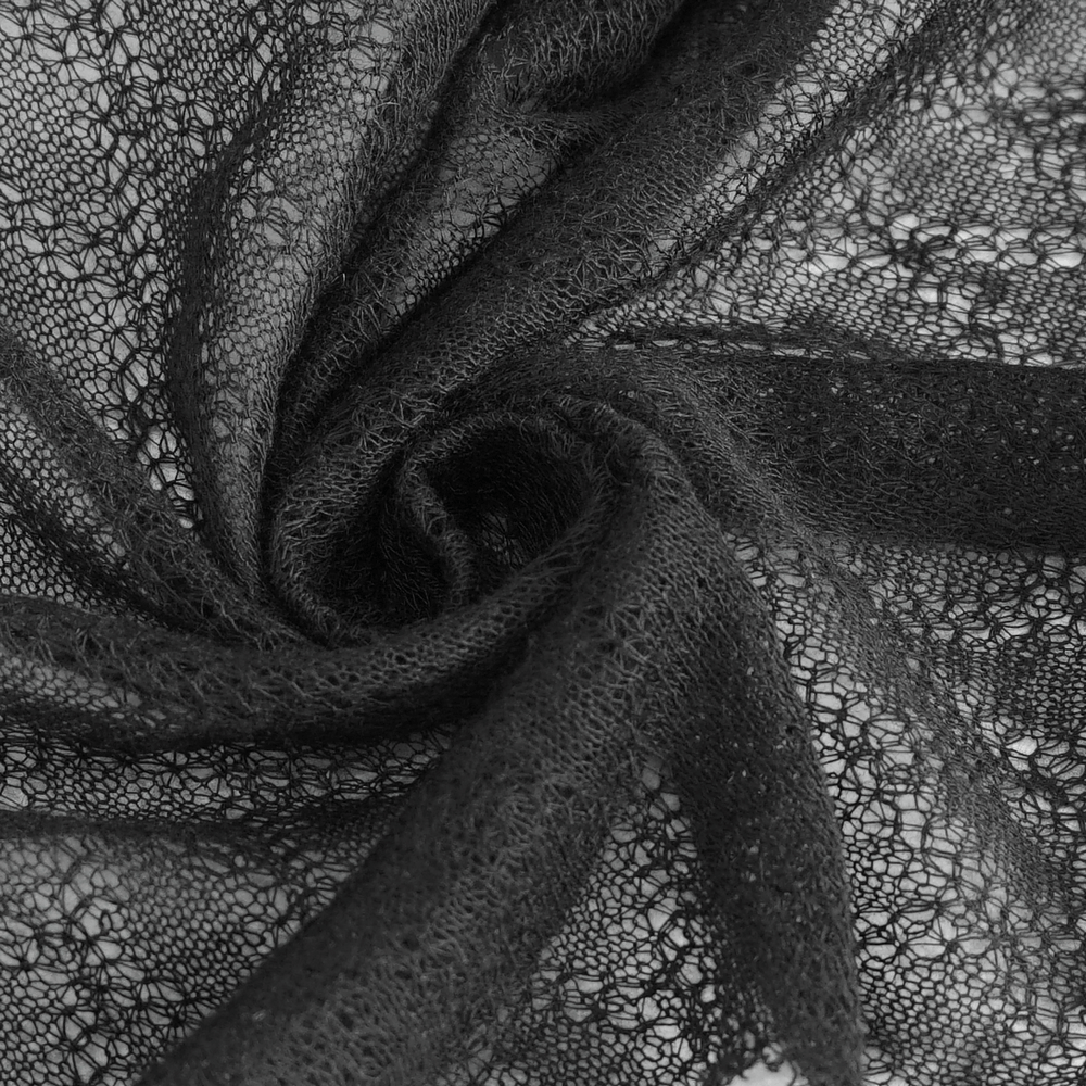 Close-up of elegant black sheer lace fabric, showcasing intricate patterns and textures for fashion designs.
