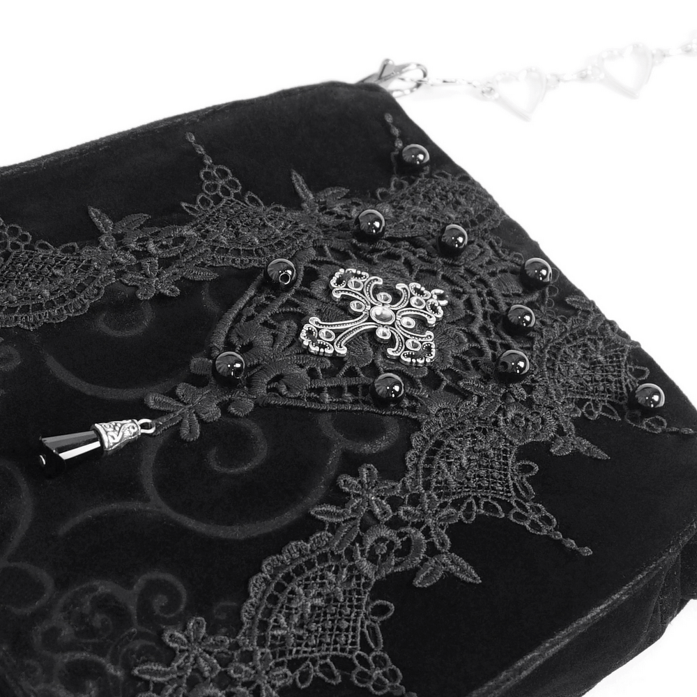 Elegant black velvet shoulder bag with gothic floral embroidery and silver cross detail, perfect for a striking look.